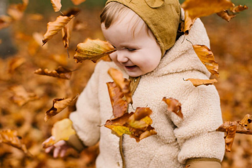 Small child in fall leaves