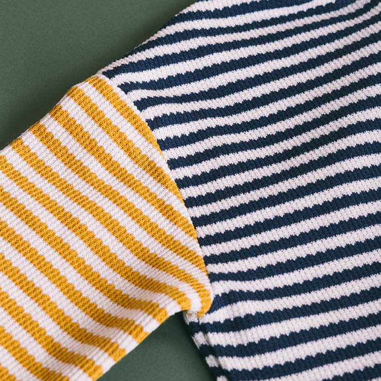 A close-up of a neatly folded fabric with alternating horizontal stripes.