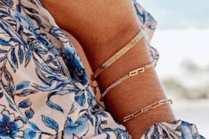 a close up of a woman's wrist wearing gold bracelets